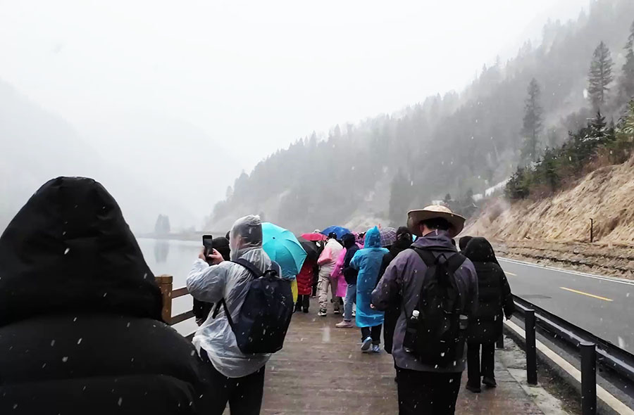 หิมะตกที่จิ่วจ้ายโกว Arrow Bamboo Lake ทะเลสาบไผ่ลูกศร ผู้คนกางร่ม และใส่เสื้อกันฝน