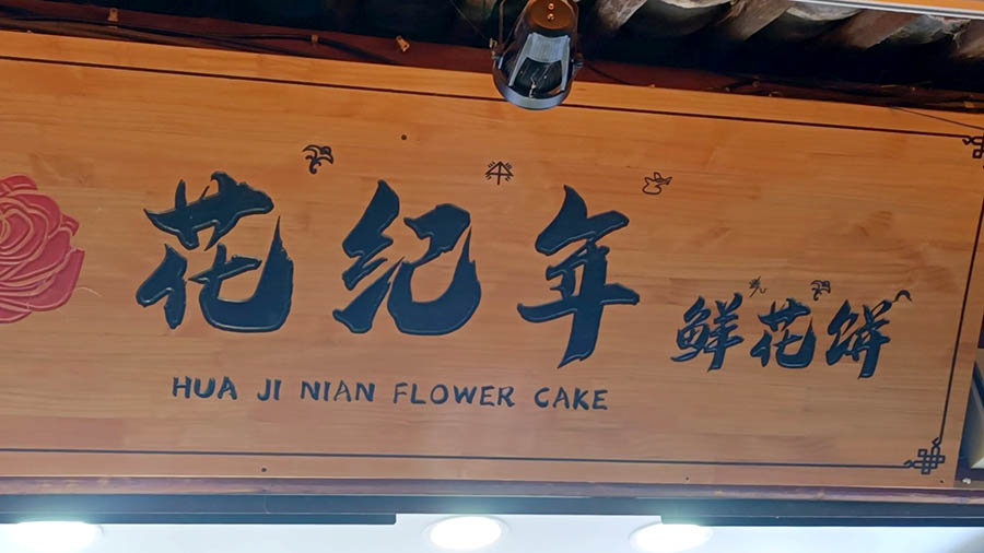 บนป้ายร้านขายของในลี่เจียง มีอักษรตงปากำกับด้านบน
