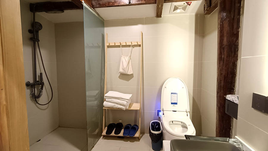 ห้องน้ำแบ่งโซนเปียก-แห้ง มีชักโครกอัตโนมัติ ไม่มีประตูห้องน้ำ แต่เป็นม่านกั้น Yueshang Mountain Viewing Courtyard hotel, Lijiang old town