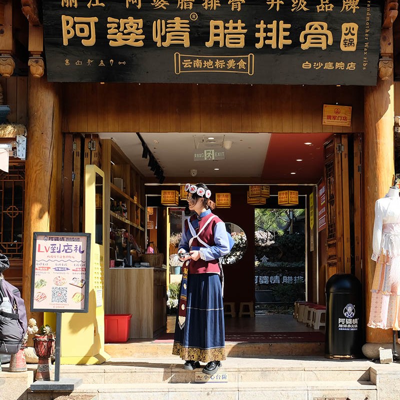 ผู้หญิงในชุดพื้นเมืองน่าซีที่หมู่บ้านไป๋ชา ลี่เจียง ยูนนาน ประเทศจีน a woman in Naxi costume at Baisha Ancient Town, Lijiang, Yunnan, China