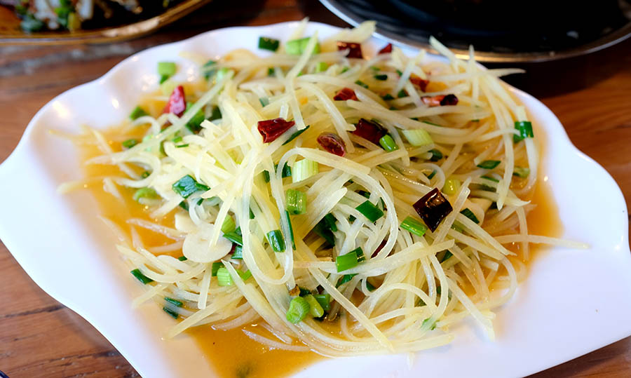 มันฝรั่งผัดน้ำมันชา ร้าน Xinguo Najia Restaurant หมู่บ้านไป๋ชา ลี่เจียง ยูนนาน ประเทศจีน Stir-fried Shredded Potatoes at Baisha Ancient Town, Lijiang, Yunnan, China