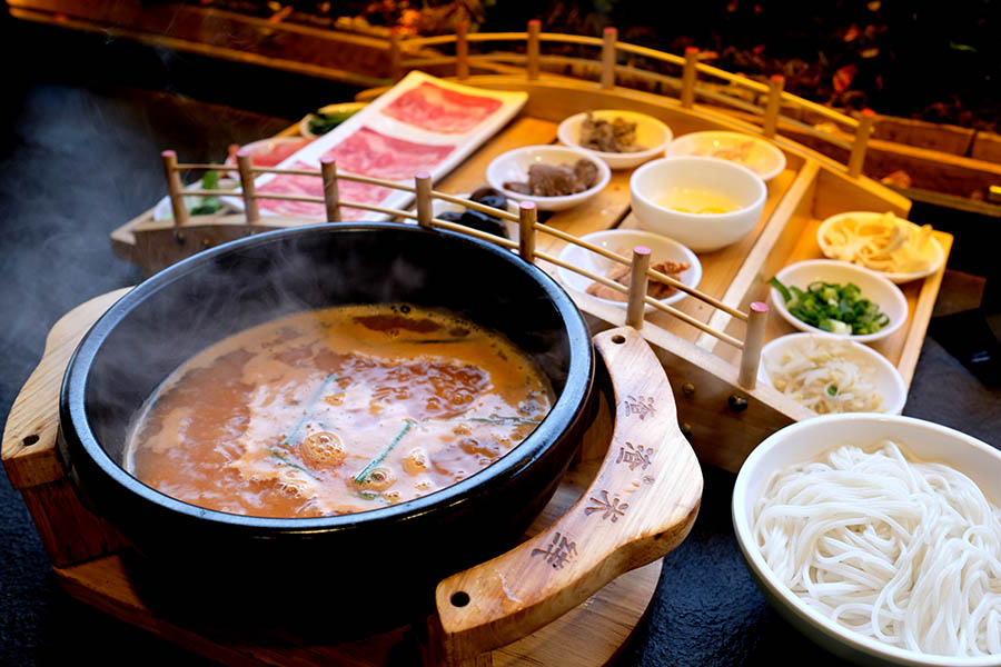 เส้นหมี่ข้ามสะพานในซุปมะเขือเทศ ร้านก๋วยเตี๋ยวข้ามสะพาน ZhaZha Mi Xian เมืองเก่าลี่เจียง มณฑลยูนนาน ประเทศจีน Beef Tomato Crossing Bridge Noodles at ZhaZha Mi Xian restaurant Lijiang old town, Yunnan province, China