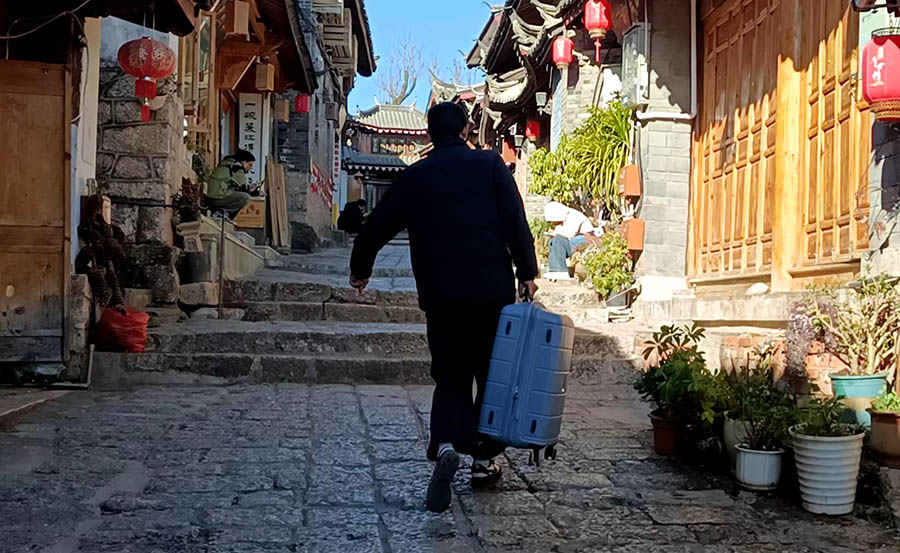 hotel owner carries luggage for us at Lijiang old town, Yunnan, China เจ้าของโรงแรมยกกระเป๋าเดินทางไปส่งพวกเรา เมืองเก่าลี่เจียง มณฑลยูนนาน ประเทศจีน