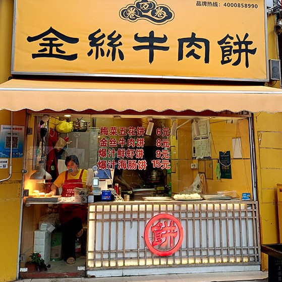 fried bun snack store at Zhongshan Rd. walking street in old town Qingdao, Qingdao, Shandong province, China ร้านขายซาลาเปาทอดไหมทอง ถนนคนเดินจงซาน ย่านเมืองเก่า, ชิงเต่า มณฑลชานตง ประเทศจีน