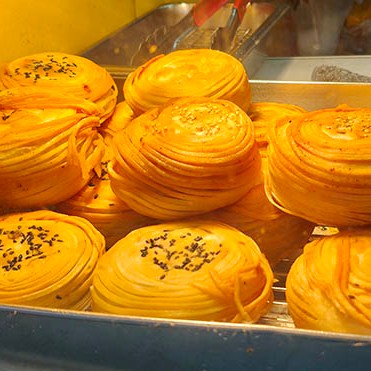 fried bun snack store at Zhongshan Rd. walking street in old town Qingdao, Qingdao, Shandong province, China ร้านขายซาลาเปาทอดไหมทอง ถนนคนเดินจงซาน ย่านเมืองเก่า, ชิงเต่า มณฑลชานตง ประเทศจีน